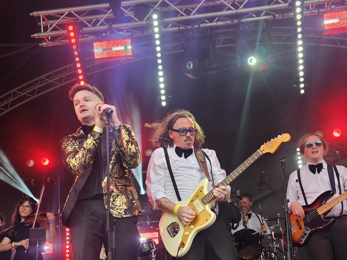 The band performing on an outdoor festival stage