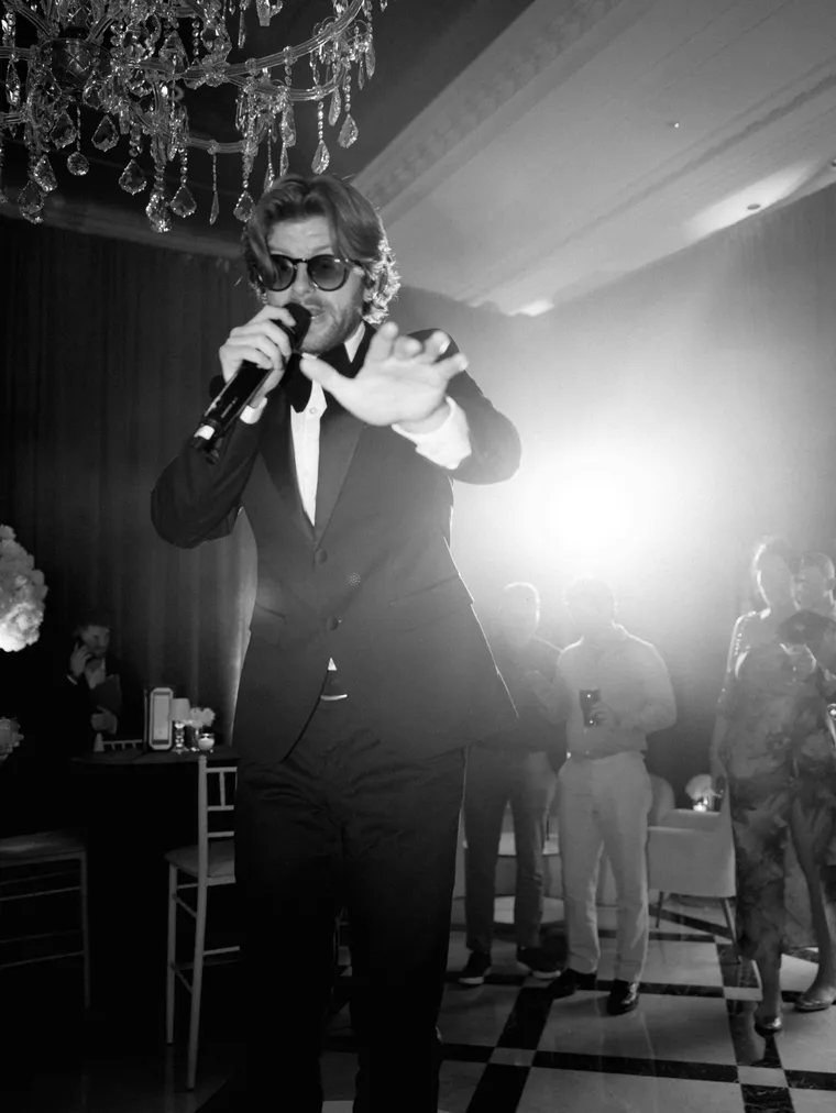Frontman singing beneath a crystal chandelier